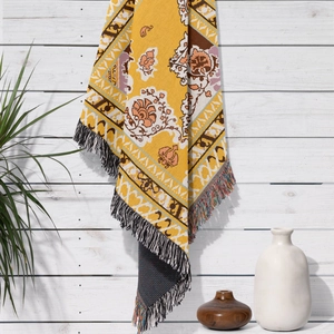 Detailed close-up of Bohemian cotton blanket with ethnic jacquard pattern and fringe