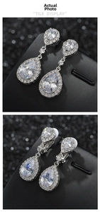Macro detail of silver clip-on earrings with teardrop cubic zirconia and halo setting