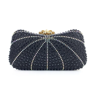 Close-up of luxury black evening clutch with radiant rhinestone patterns and gold clasp