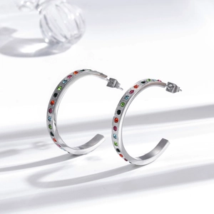 Minimalist C-shaped stainless steel earrings with multi-colored rainbow stones on white background