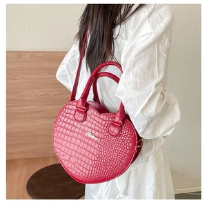Gros plan du sac à main rouge en forme de cœur avec texture croco et logo Balina