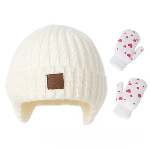 Detailed knit texture of cream baby trapper hat with heart pattern winter gloves