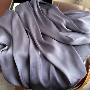 Detail shot of smooth dark grey satin scarf with premium glossy silk texture and elegant drape