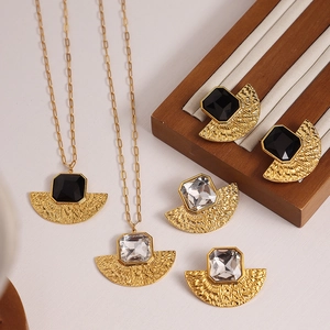 Elegant gold fan pendant necklaces and earrings set with inlaid black and clear glass stones