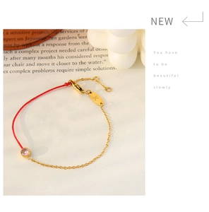 Detail of red rope and gold chain bracelet with pink zircon stone and K letter charm