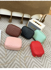 Flat lay of small crossbody bags with V-shaped quilting and gold chains in five colors