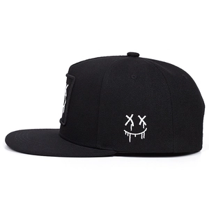Cappellino da baseball nero con ricamo smiley bianco mostrato da un'angolazione di 45 gradi