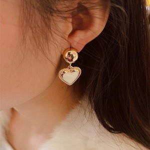 French vintage 18K gold plated heart earrings with cream enamel on a female model