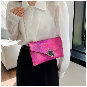 Dettaglio della pochette a busta fucsia con motivo a coccodrillo e finitura cangiante