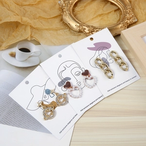 Chic jewelry set display featuring gold chain, pearl heart, and star earrings on art cards