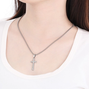 Polished silver cross pendant necklace with box chain on model neckline view