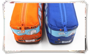 Close-up of school bus shaped canvas pencil cases in orange and blue with cat driver detail