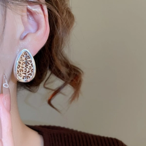 Close-up of leaf-shaped leopard print earring on model with silver drop design
