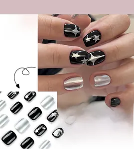 Detail of Y2K black and silver press-on nails featuring metallic star patterns and kit