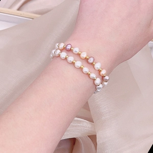 Close-up of double-layer freshwater pearl bracelet on wrist with gold bead accents