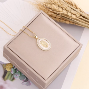 Detail of copper micro-set zircon Virgin Mary pendant with mother of pearl on jewelry box