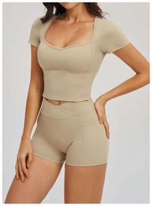 Detail of cross waist yoga shorts and square neck cropped top in beige seamless fabric