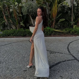Détail d'une robe longue blanche à une épaule avec fente haute et détails de fronces