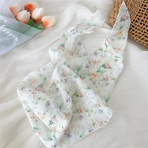Close-up of lightweight floral silk scarf featuring elegant pink and green flower patterns