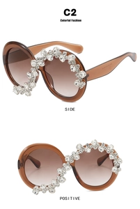 Detail of oversized round sunglasses with tea gradient lenses and crystal flower embellishments