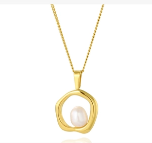 Detail of irregular gold ring pendant featuring a baroque pearl on a fine stainless steel chain
