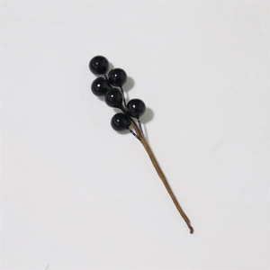 Close-up of artificial black berries on a textured brown stem for DIY floral arrangements