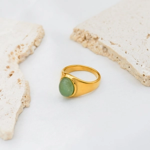 Detailed view of an 18k gold plated stainless steel ring with a green oval gemstone