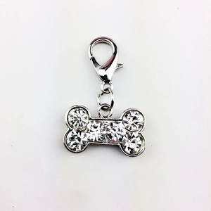 Macro view of silver bone-shaped dog tag pendant with sparkling rhinestones and lobster clasp