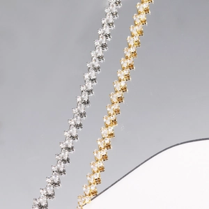 Macro detail of marquise-cut zircon tennis bracelets in silver and gold finishes