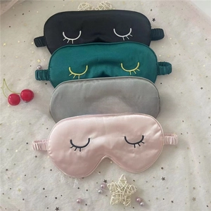 Detailed view of four silk sleep masks in black, green, gray and pink with eyelash embroidery