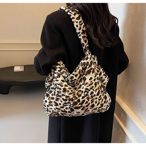 Detail of leopard print quilted shoulder bag paired with a black wool coat for autumn style