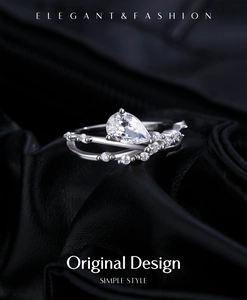 Macro shot of silver crisscross ring with a large pear-shaped zircon on black leather