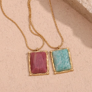 Macro shot of 18K gold plated necklaces featuring pink and green rectangular natural stones