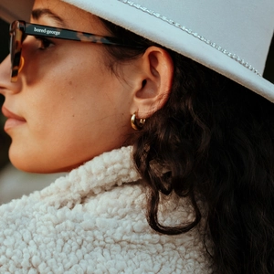 Minimalist 18k gold plated stainless steel hoop earrings on female model with white hat
