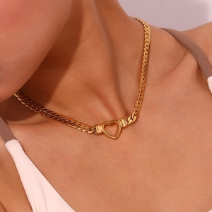 Golden flat chain choker with hollow heart pendant worn by a model in warm light