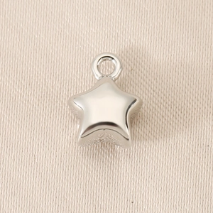 Macro shot of silver star pendant charm with a polished metallic finish and smooth loop
