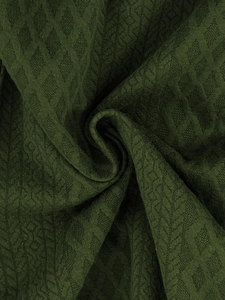 Detailed macro view of dark green jacquard knit fabric with geometric diamond pattern