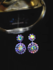 Macro shot of layered circular snowflake earrings featuring iridescent crystal rhinestones