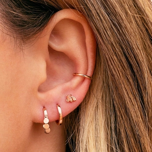 Rose gold earrings set featuring bee stud and hoop dangles on model's ear