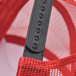 Detail of adjustable black snapback closure on a breathable red mesh trucker baseball hat