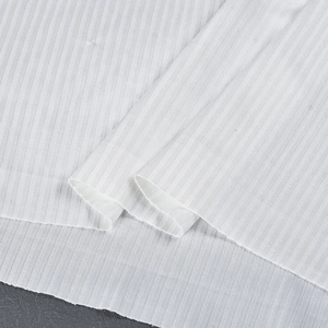 Gros plan sur un tissu en maille côtelée blanche avec texture fine et drapé doux