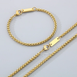 Dettaglio del set collana e bracciale a spiga in acciaio titanio dorato con ciondolo quadrato