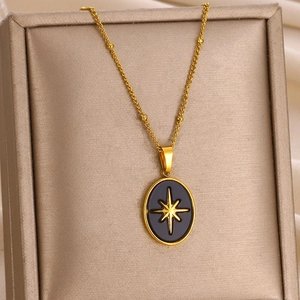 Detailed shot of a gold oval pendant with star motif in a luxury jewelry box