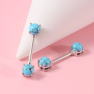 Close-up of silver stainless steel nipple rings with blue turquoise bead accents