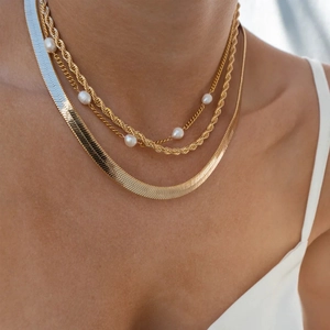 Close-up of triple layered 18k gold plated necklace with pearls and snake chain