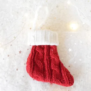 Red and white cable knit Christmas stocking hanging decoration with classic patterns