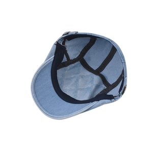 Detail view of denim beret interior with black reinforced edging and quilted lining