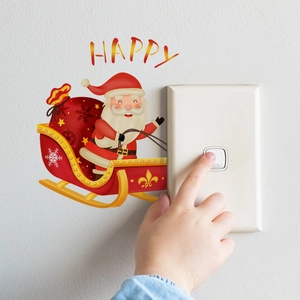 Luminous Christmas wall sticker showing Santa in a red sleigh over a light switch