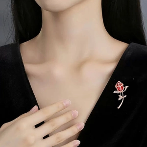Elegant red rose brooch with crystals on black velvet dress, showing realistic floral design