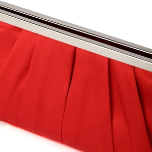 Macro detail of red pleated satin texture with silver metal clasp on evening clutch bag